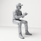 Photo produit de modélisme pour diorama 3 : figurine assise d’un spectateur masculin avec casquette et mains jointes (B068)