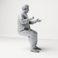 Photo produit de modélisme pour diorama 1 : figurine assise : homme gesticulant avec pull, pantalon et tongs (a165)